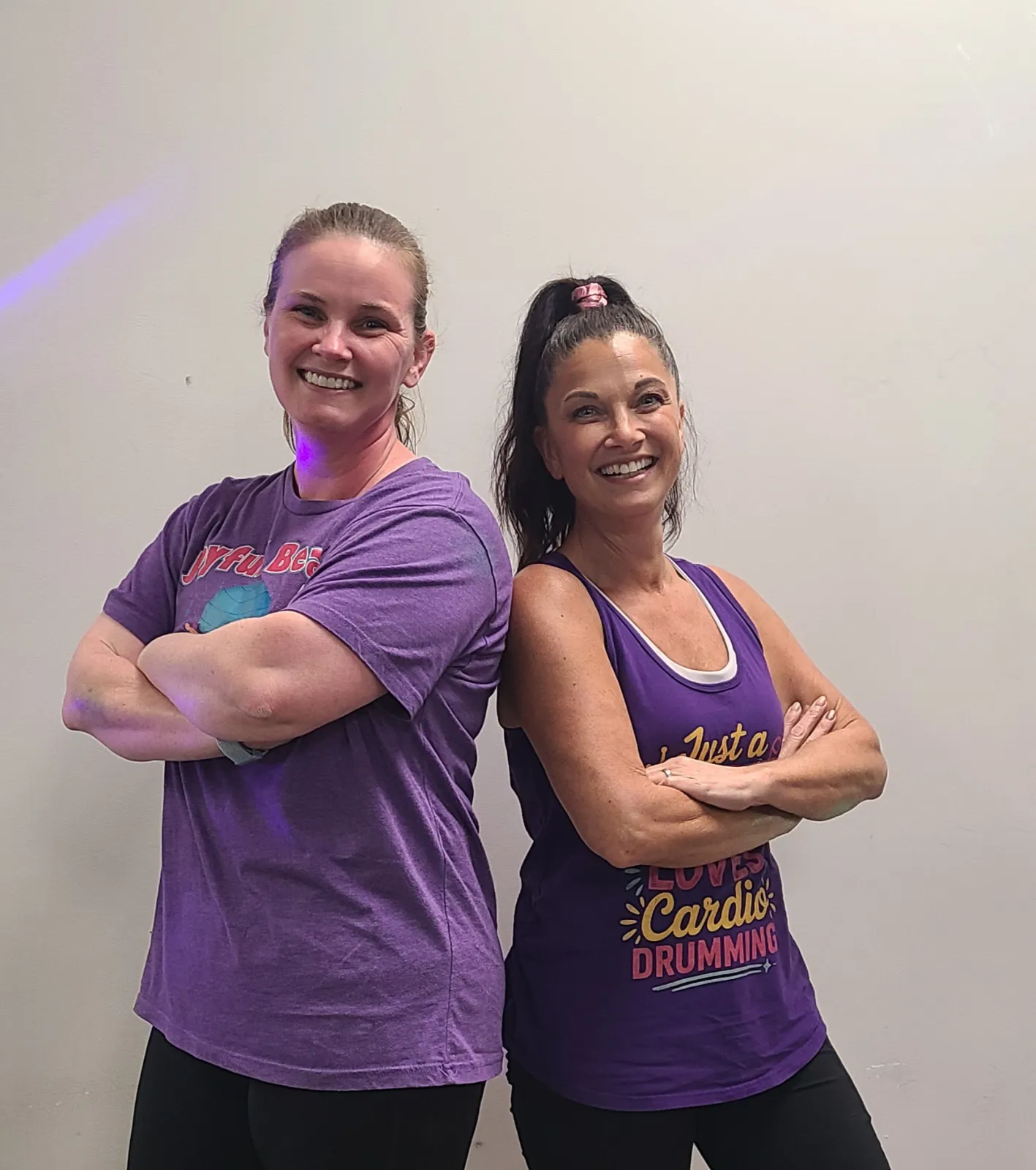 Coach Amy and Coach Bobbie standing back to back